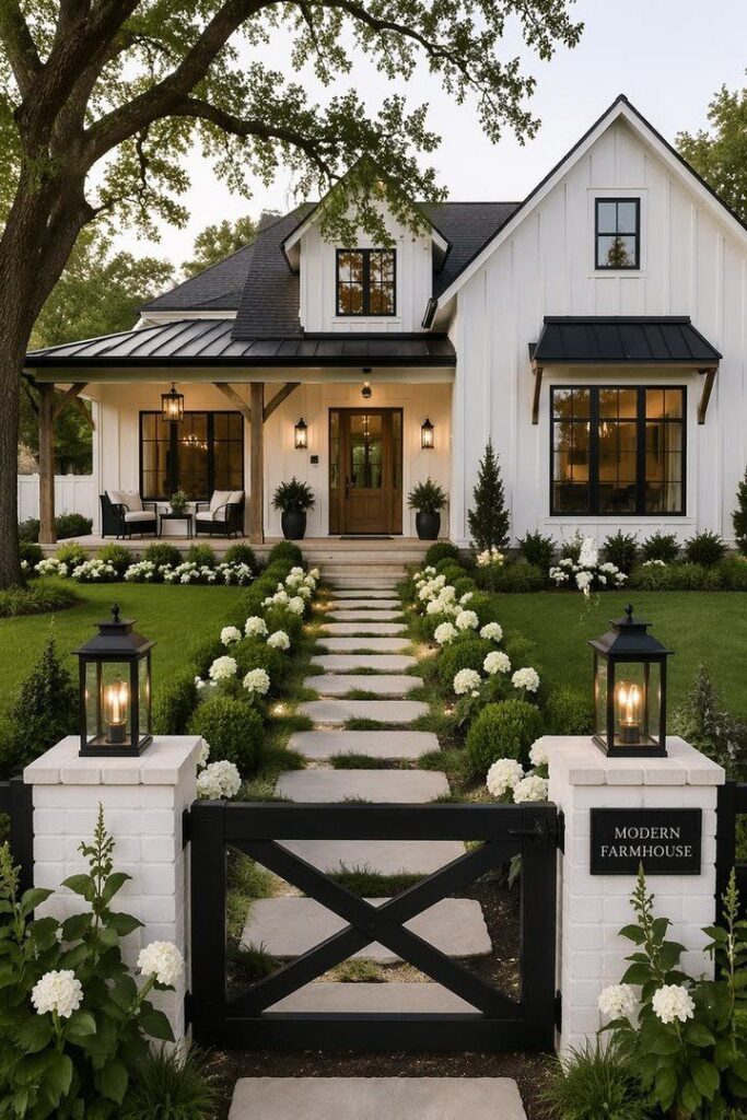 White modern farmhouse with black trim, a stone walkway, and white hydrangea bushes in the garden.