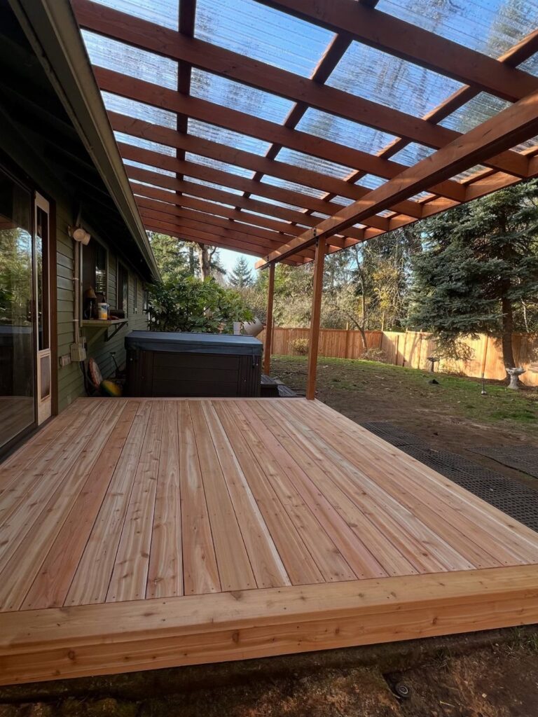 A new wooden deck with a large timber pergola structure in a backyard setting.